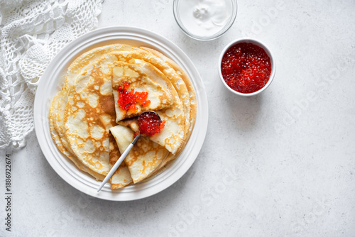 Homemade thin crepes with red caviar