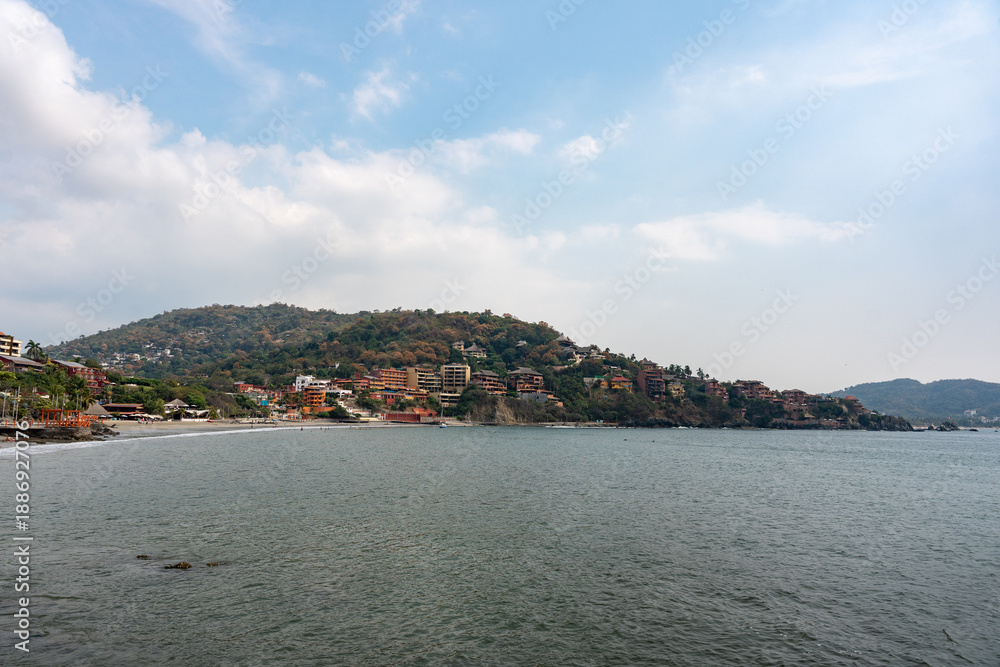 Fototapeta premium La Madera Beach in Ixtapa Zihuatanejo, Costa Grande, Guerrero. Coastal scene surrounded by hotels and tourists enjoying the sea and sun. Mexico, January 19, 2026