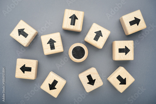 Wooden arrow blocks pointing in different directions from a central point, symbolizing lack of alignment, fragmented strategy and a world reorganizing beyond traditional order