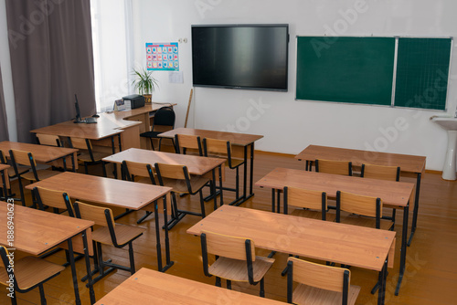 a school room with desks and an interactive whiteboard. education