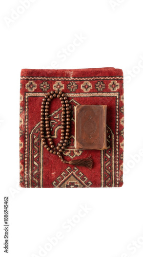 A folded red prayer rug, a holy Quran in a leather cover, and wooden prayer beads are arranged for Islamic prayer on a transparent background.