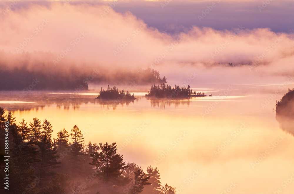 Fototapeta premium Islands in early morning fog on a Boundary Waters lake in northern Minnesota during autumn