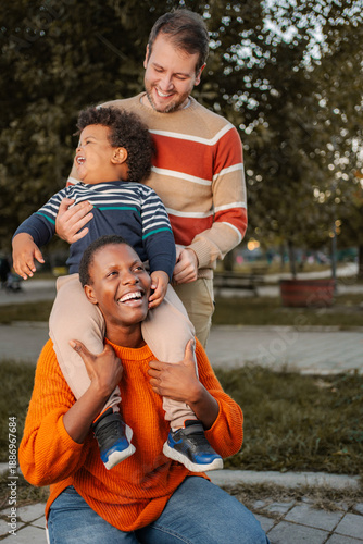Fotografie Happy multiracial family playing in park outdoors