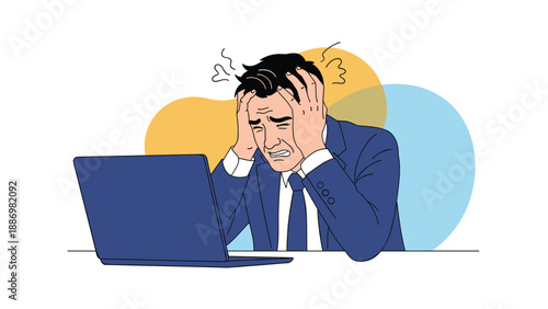 Distressed businessman in a blue suit sitting at a laptop and holding his head while crying from stress and failure.
