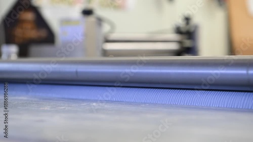 Rotating shafts of an industrial laminator in close-up in a printing house. Mechanics of rotation of metal shafts