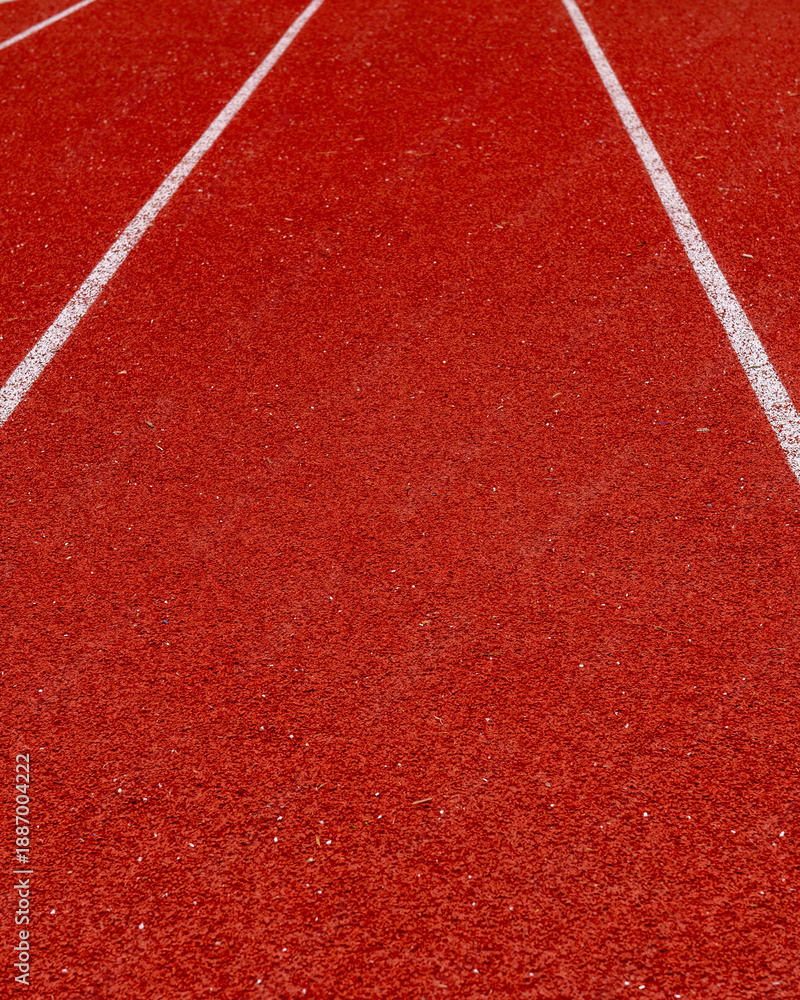Fototapeta premium Running track surface with lanes marked for races at a sports facility during daylight hours