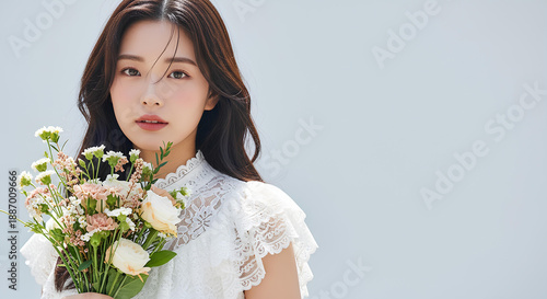 白いレースドレスを着て花束を持つ美しい女性のポートレート