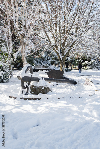 Winter city Park. The big old anchor, sidewalk and derya are heavily covered with snow. A sunny January day. After a heavy overnight snowfall. New Year's Morning. Frozen plants.