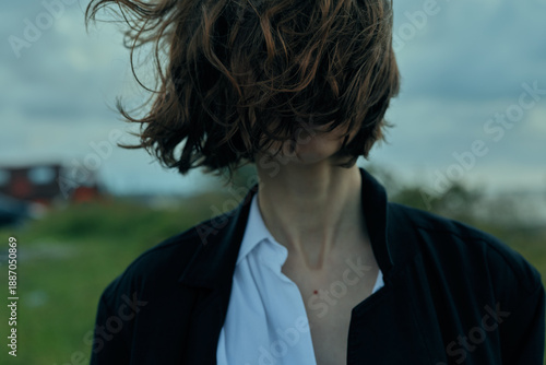 Obraz na plátně Wind swept hair and exposed neck in an outdoor setting with a blurred countrysid