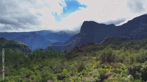 Wallpaper Mural Aerial view of lush green forest and majestic mountains under a cloudy sky create a breathtaking landscape, La Possession, Saint-Paul, Reunion. Torontodigital.ca