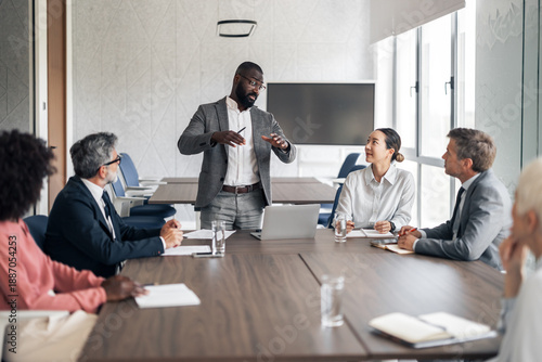 Black businessman leading a diverse team meeting in boardroom