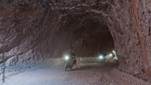 Motorcycle convoy riding on the famous Kemaliye Tasyol stone road carved into rocks in Dark Canyon, Turkey. Dramatic canyon and mountain road ideal for travel, adventure and cinematic road trip concep