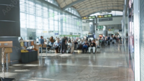 Tableau sur toile Busy airport terminal with defocused travelers sitting and waiting under arched