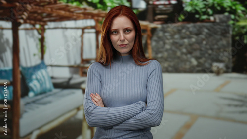 Free Download Woman standing outdoors in city street with serious expression posing against urban background - GFXLoad