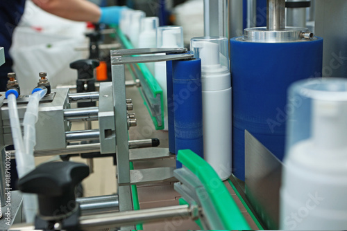 Tablou pe pânză Bottles without labels on the conveyor of a cosmetics factory