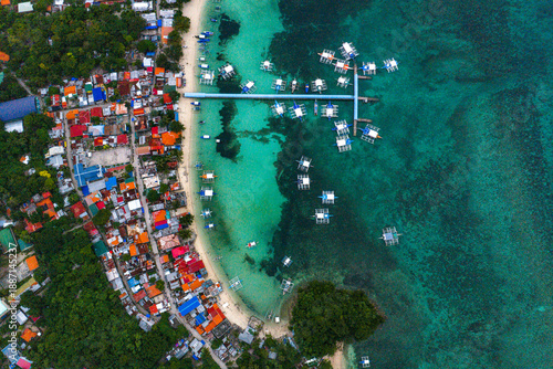 High Angle Drone Shot of Malapascua Island Surrounded by Vibrant Coral Reefs and Deep Blue Sea.