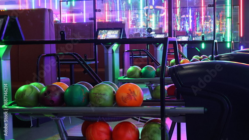 Modern bowling alley interior with neon lights and vibrant graffiti numbers.