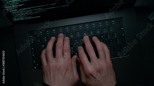 Fingers Typing on the Keyboard, Entering Code into a Text Editor – the Camera Dollies Out Revealing the Developer Working on a Laptop in a Dark Room
