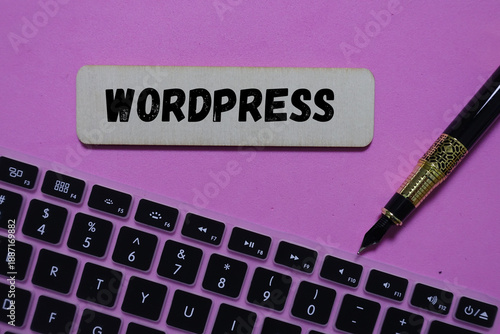 WordPress sign above a computer keyboard and pen