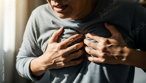 Man clutching chest in pain from heart attack or disease