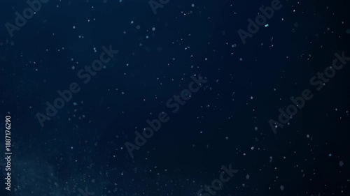 Deep, dark blue background with tiny, scattered, luminous particles
