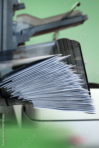 An enveloping machine at the lettershop prepares and processes letters and mailings for the post office or print shop. Print sorted with spine. Lettershop or bookbinder manufacture.