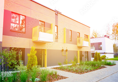 Photography Modern townhome Exterior With Green Accents, Sunlight in Serene Neighborhood Setting