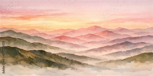 A misty sunrise glows over a mountain landscape as morning sunlight pierces through clouds and fog to illuminate the snowy peaks and hills across the horizon