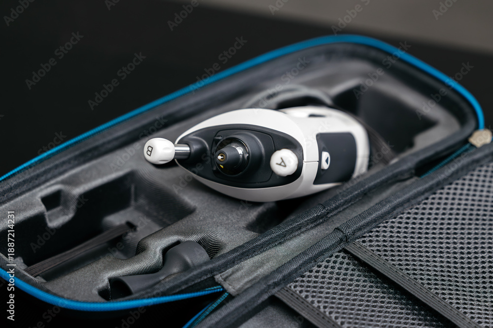 Naklejka premium Portable handheld tonometer for glaucoma measurement in a protective case, featuring a sleek design and ergonomic controls for easy use in clinical settings