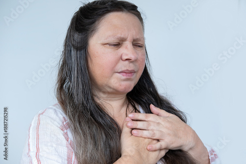 caucasian mature woman experiences sudden chest pain behind sternum, clutching chest, Arterial hypertension, Myocarditis or Arrhythmia, heart disease experiences, Risk factors