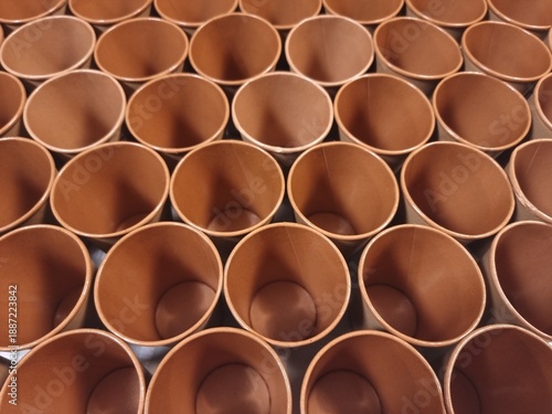 Top down pattern of empty brown paper coffee cups organized in rows
