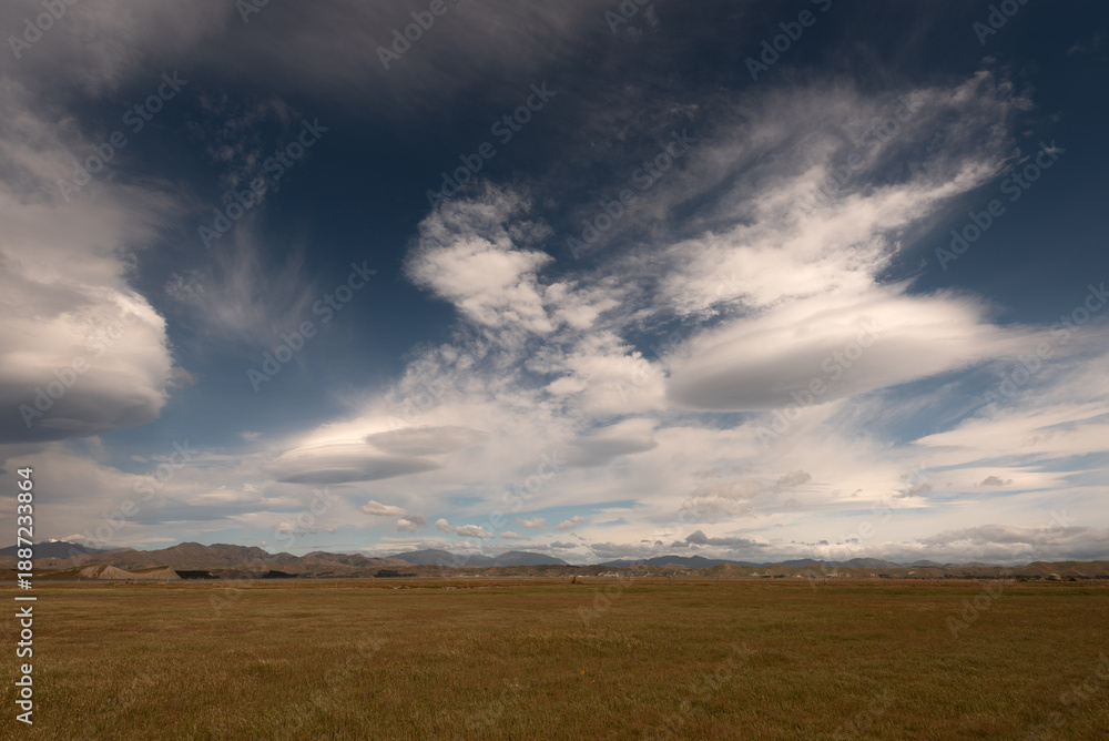Obraz premium Lenticular clouds forming over the northern end of the Inland Kaikoura Range, viewed from Lake Grassmere, Marlborough, New Zealand.