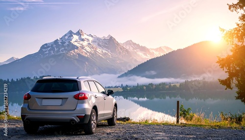 Silver SUV parked with a scenic mountain backdrop at sunset.