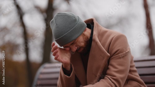 Upset Man Crying and Rubbing His Eyes While Contemplating Outdoors