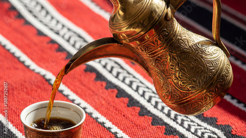 Pouring Arabic Coffee from Golden Dallah on Sadu Fabric

