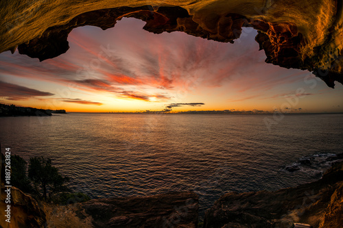Photography Sunrise over the ocean at Bronte Beach in Sydney, Australia, with a calm coastal view and a path leading toward the shoreline in early morning light