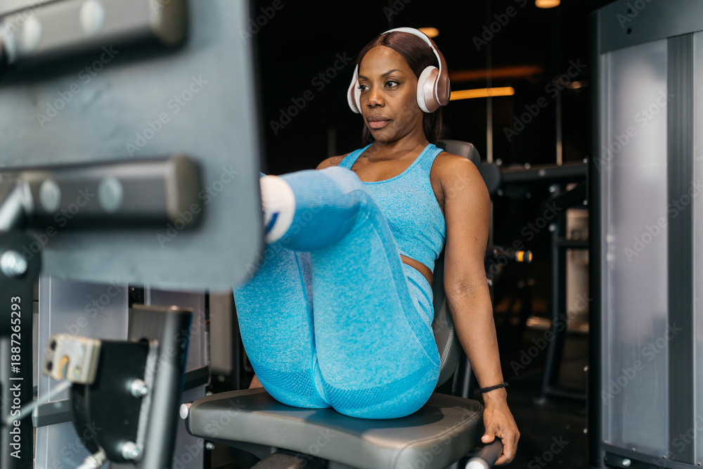 © ADDICTIVE STOCK - Hotel gym workout with exercise machine and headphones