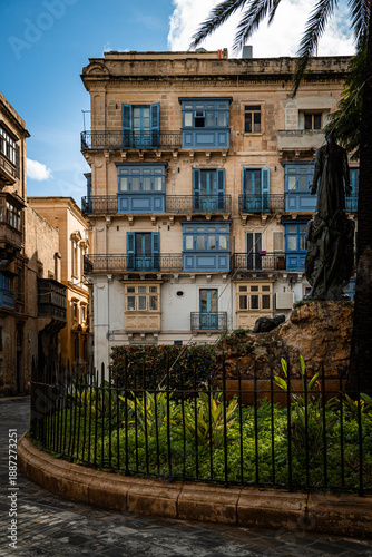 Historic Maltese townhouse in Valletta with traditional enclosed blue balconies and wrought iron details