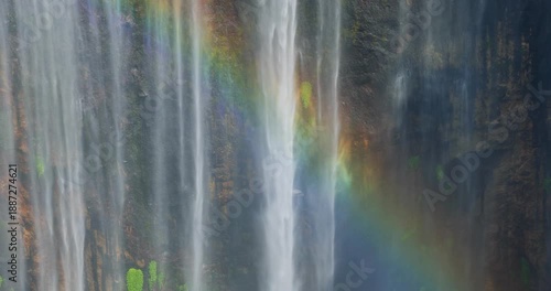 Close-Up Detail of Tumpak Sewu Waterfall with Rainbow Over Mossy Cliff, Indonesia