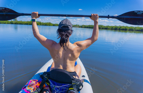 Фотография A woman is paddling a kayak on a lake