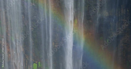 Close-Up Detail of Tumpak Sewu Waterfall with Rainbow Over Mossy Cliff, Indonesia