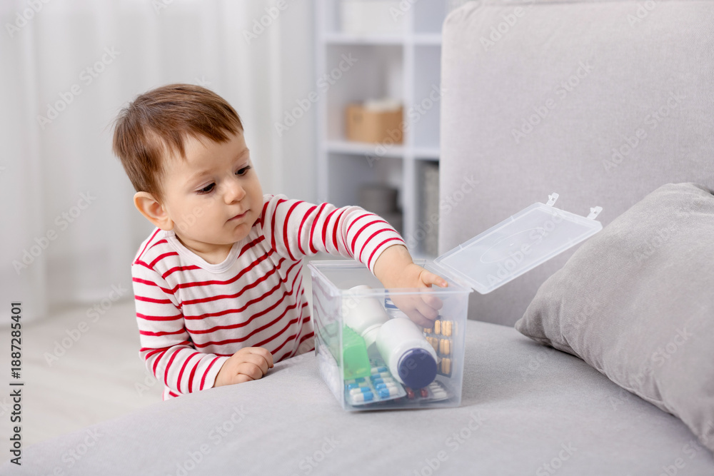 Naklejka premium Child safety at home. Little boy with box of pills indoors