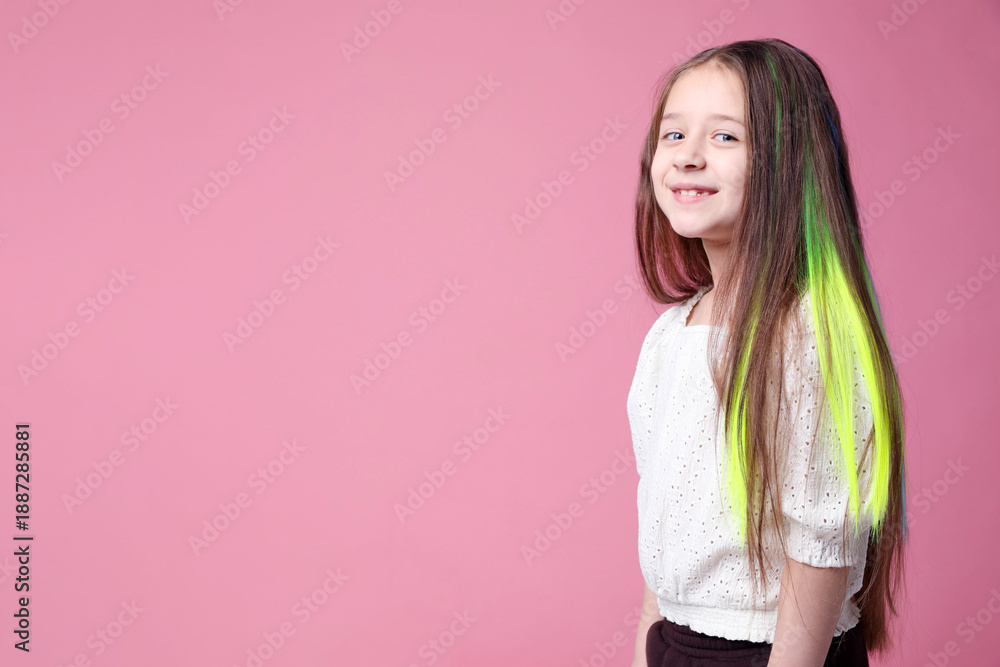 Fototapeta premium Cute girl with bright clip-in hair extensions on pink background. Space for text