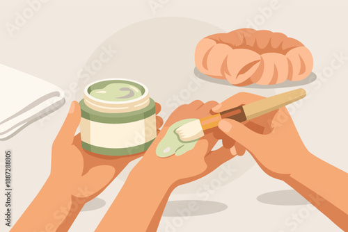 Hands applying green face mask with brush in skincare routine setting
