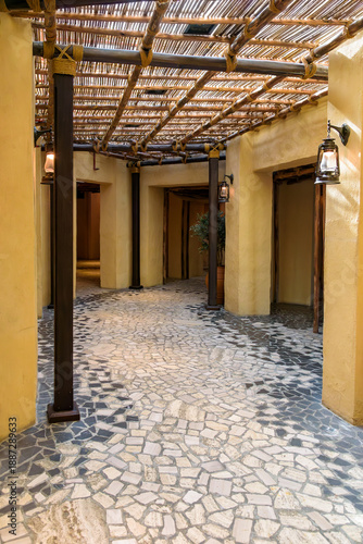 Traditional Arabic interior corridor with stone mosaic floor and bamboo ceiling
