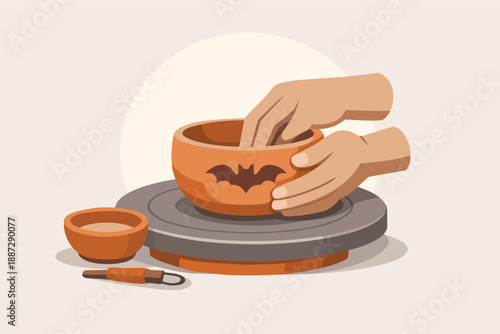 Hands crafting halloween pottery bowl with bat design on pottery wheel