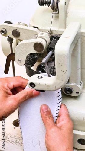 Hands sewing  shoe sole with industrial machine in footwear workshop, close up of traditional shoe manufacturing process.