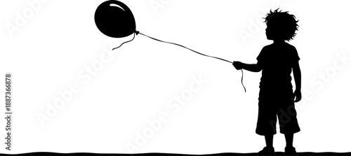 Young boy holding a black balloon.