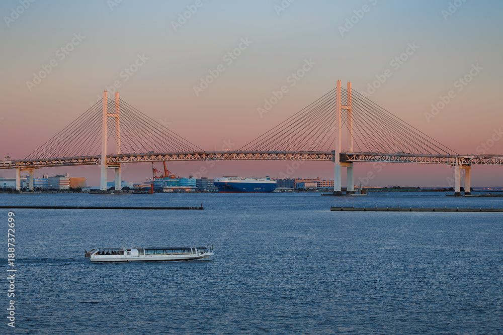 Fototapeta premium 横浜港、夕焼けに染まるベイブリッジと行きかう遊覧船