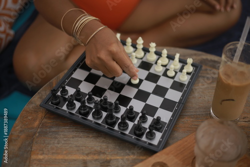 Woman’s Hand Making a Move with Magnetic Chess on a Small Board in a Café